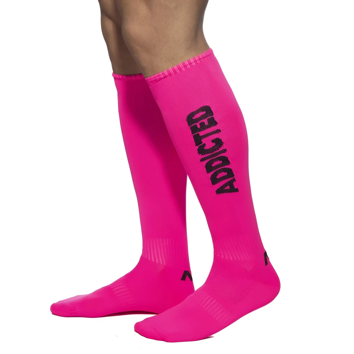 Bright pink knee-high ADDICTED neon socks with bold black lettering down the side for stylish casual wear