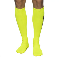 Addicted neon socks bright neon yellow knee-high athletic socks with ribbed texture and black vertical branding on side