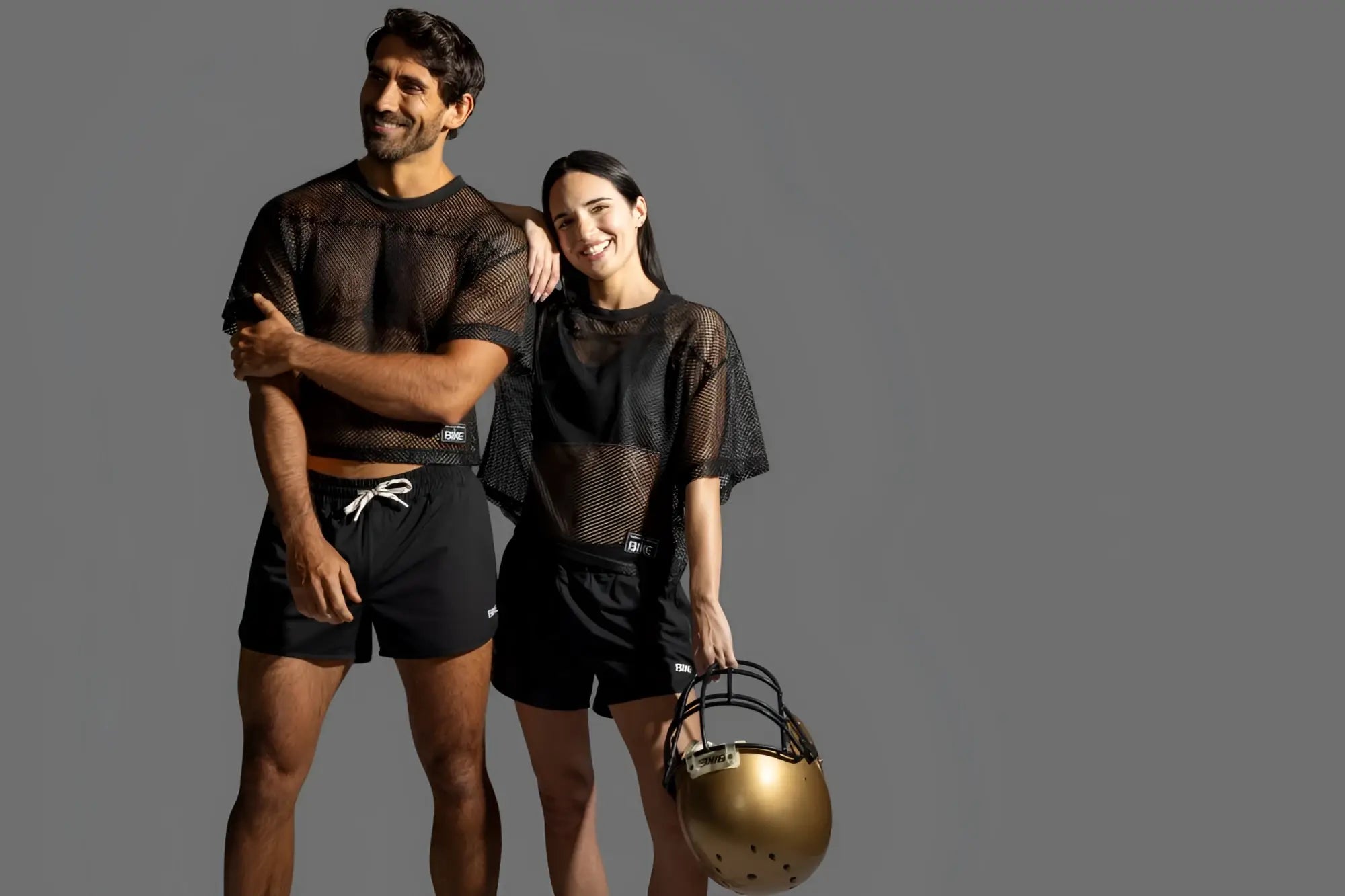 Gold football helmet with black faceguard and white laces shown alongside bike athletic bam134 black short sleeve jersey