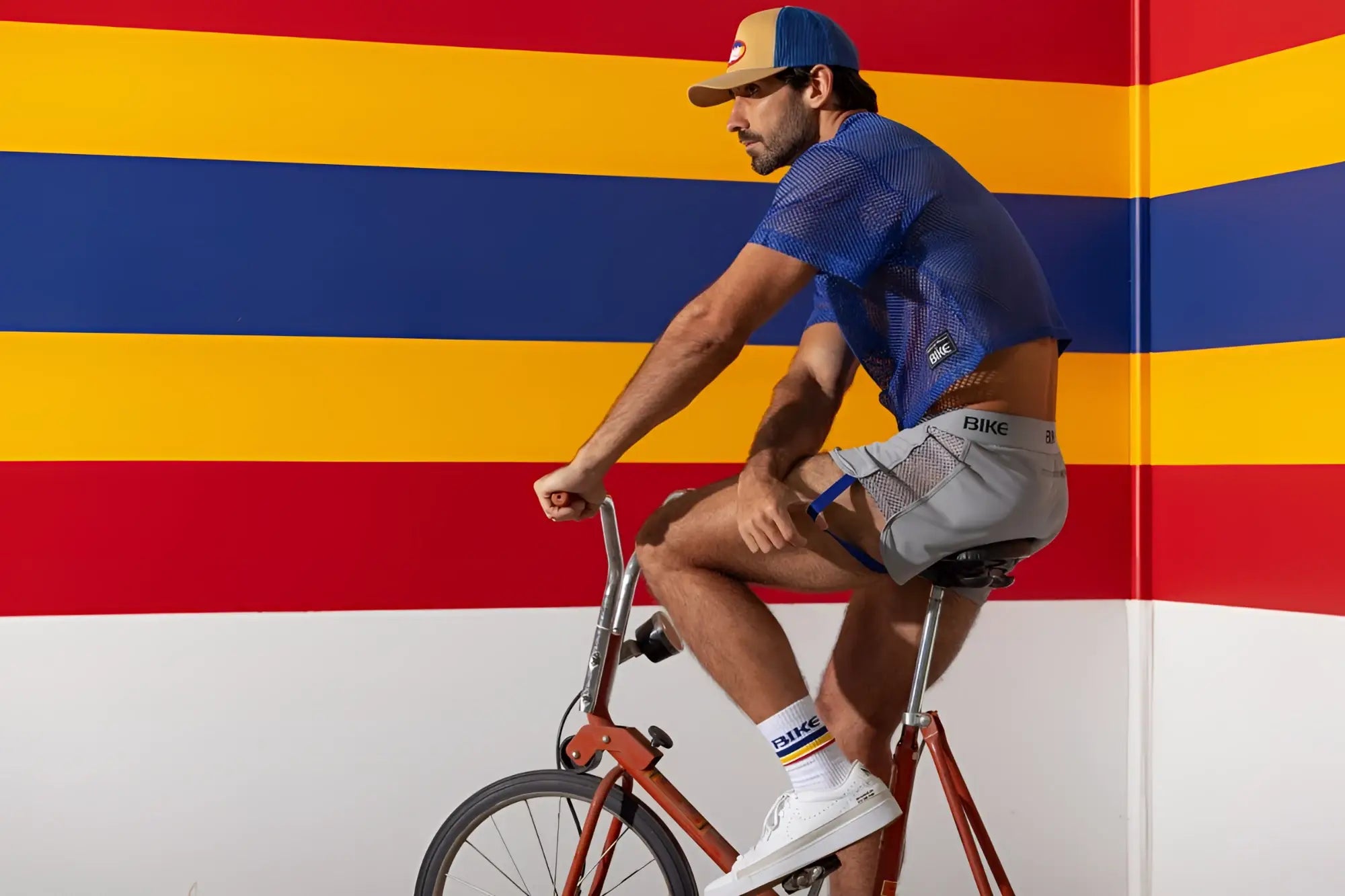 Man wearing royal blue mesh bike athletic BAM134 short sleeve practice jersey and gray bike shorts with bike branding