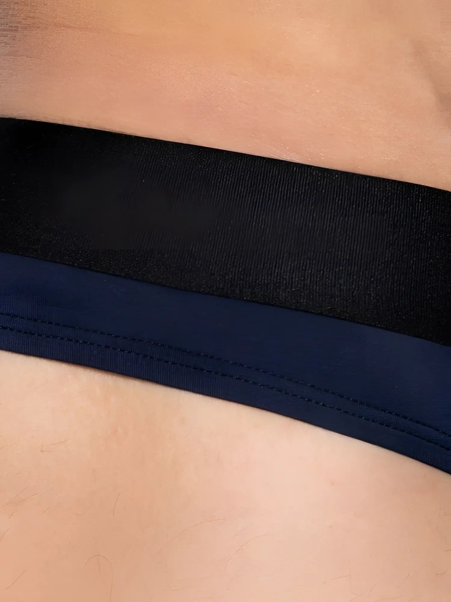 Navy blue bike athletic active thong with black elastic waistband and visible stitching in back view