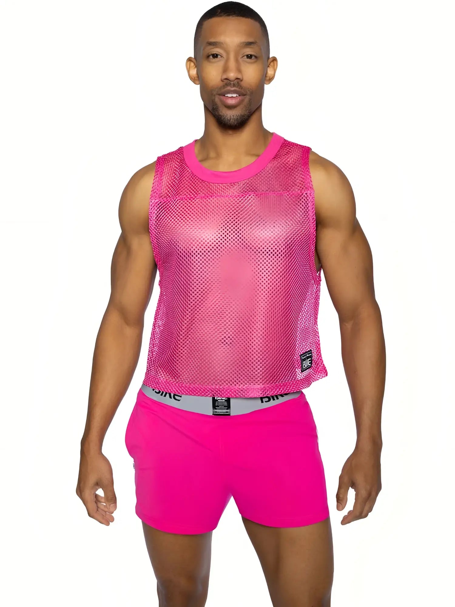 Bright pink mesh sleeveless practice jersey bike with rounded neckline and small black brand tag on lower right side