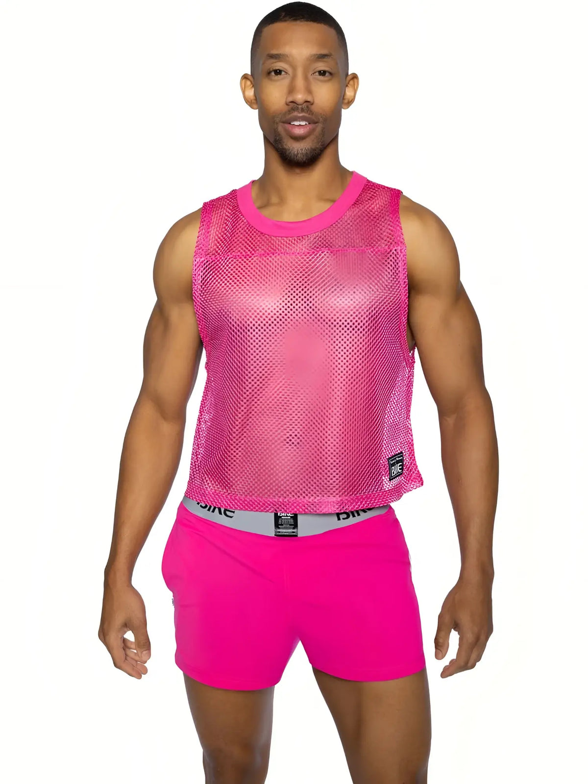 Bright pink mesh sleeveless practice jersey bike with rounded neckline and small black brand tag on lower right side