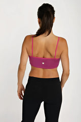 A vibrant plum bra top with thin matching straps and a sleek form-fitting sports bra design