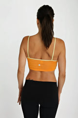 Back view of orange bra top tangerine with pale yellow straps and a small white logo on the back