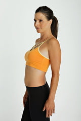 Orange sports bra top with cream trim and thin straps designed for activewear and comfort