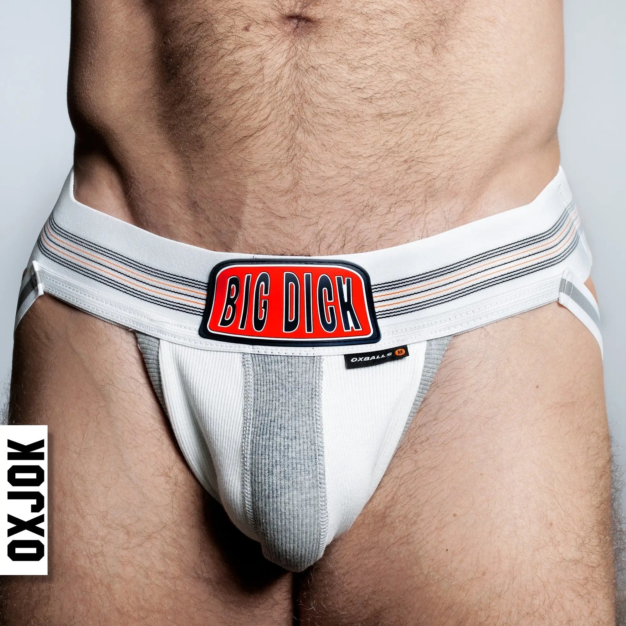 White and gray BULGER jockstrap with a bold red big dick logo patch on the front for athletic support