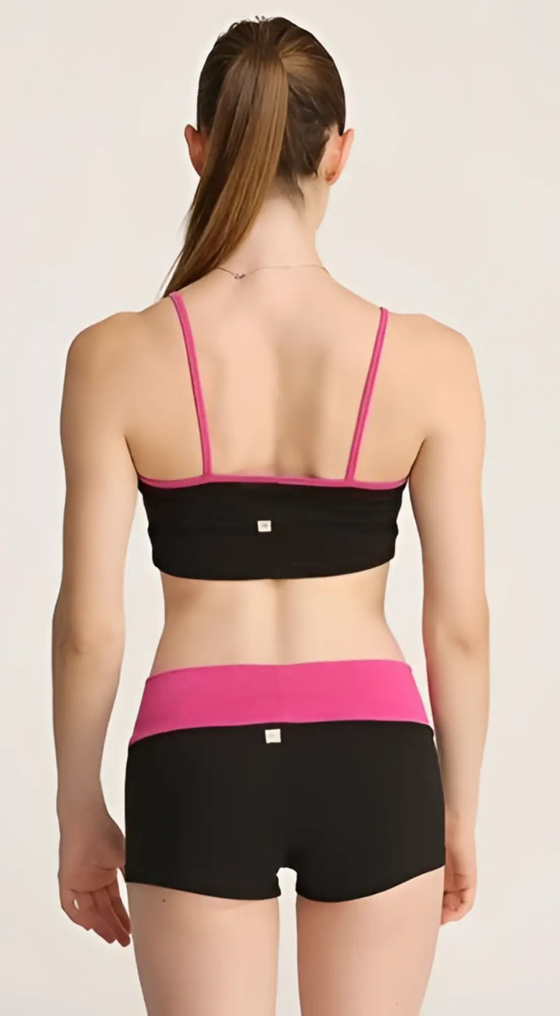 Black and pink bumble short athletic two-piece set with thin straps and elastic waistband for activewear use