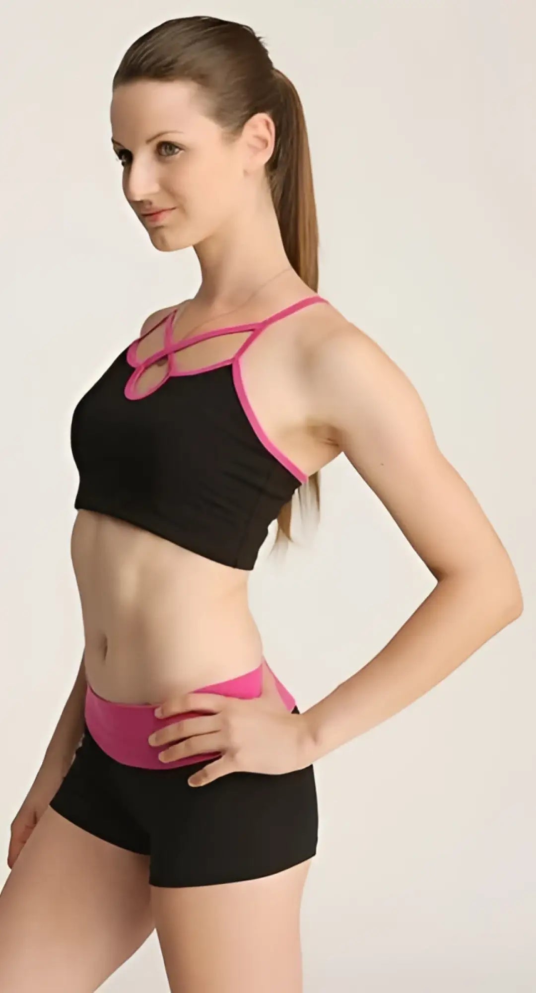 Black and pink sports bra with crisscross straps and matching waistband from the bumble short collection