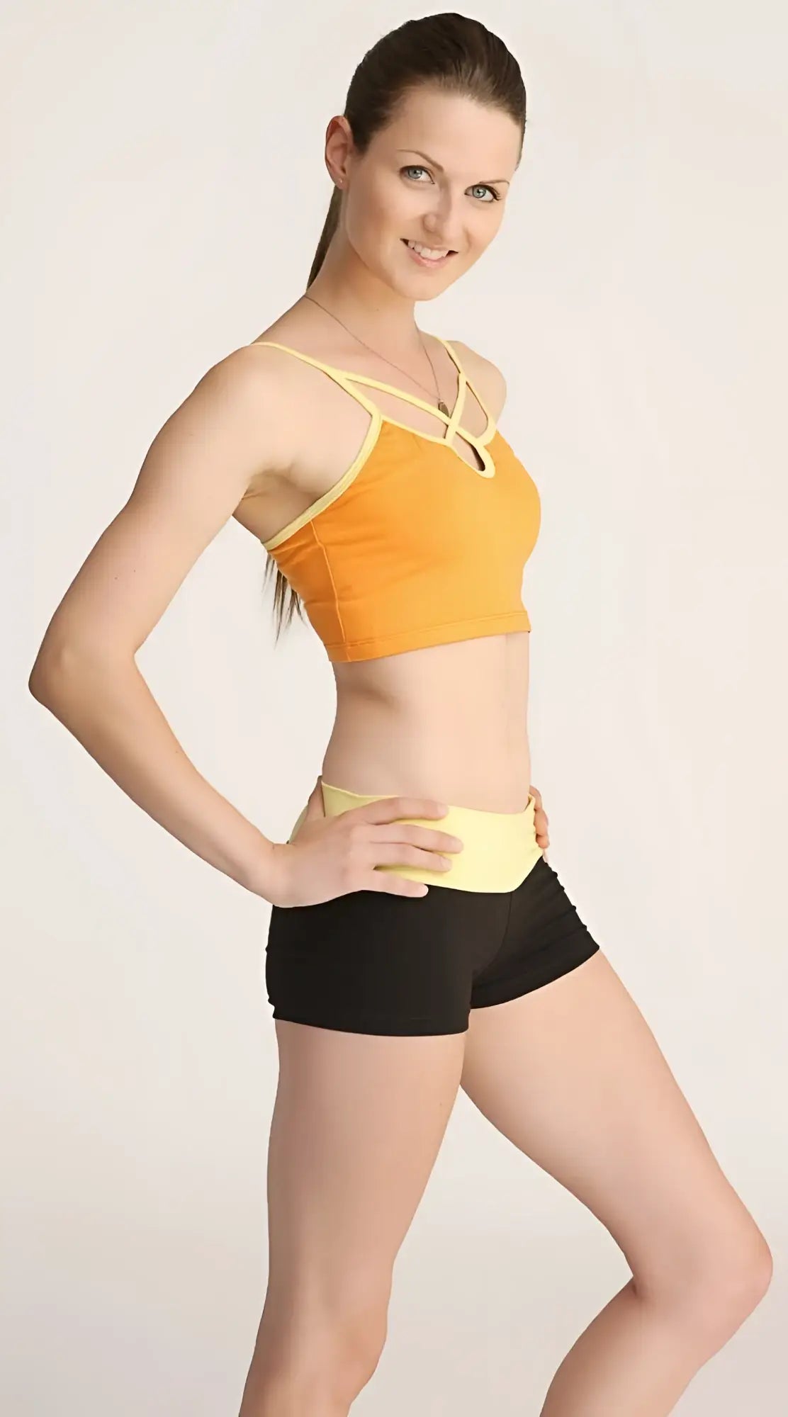 Orange and yellow bumble short sports bra with crisscross straps designed for active wear
