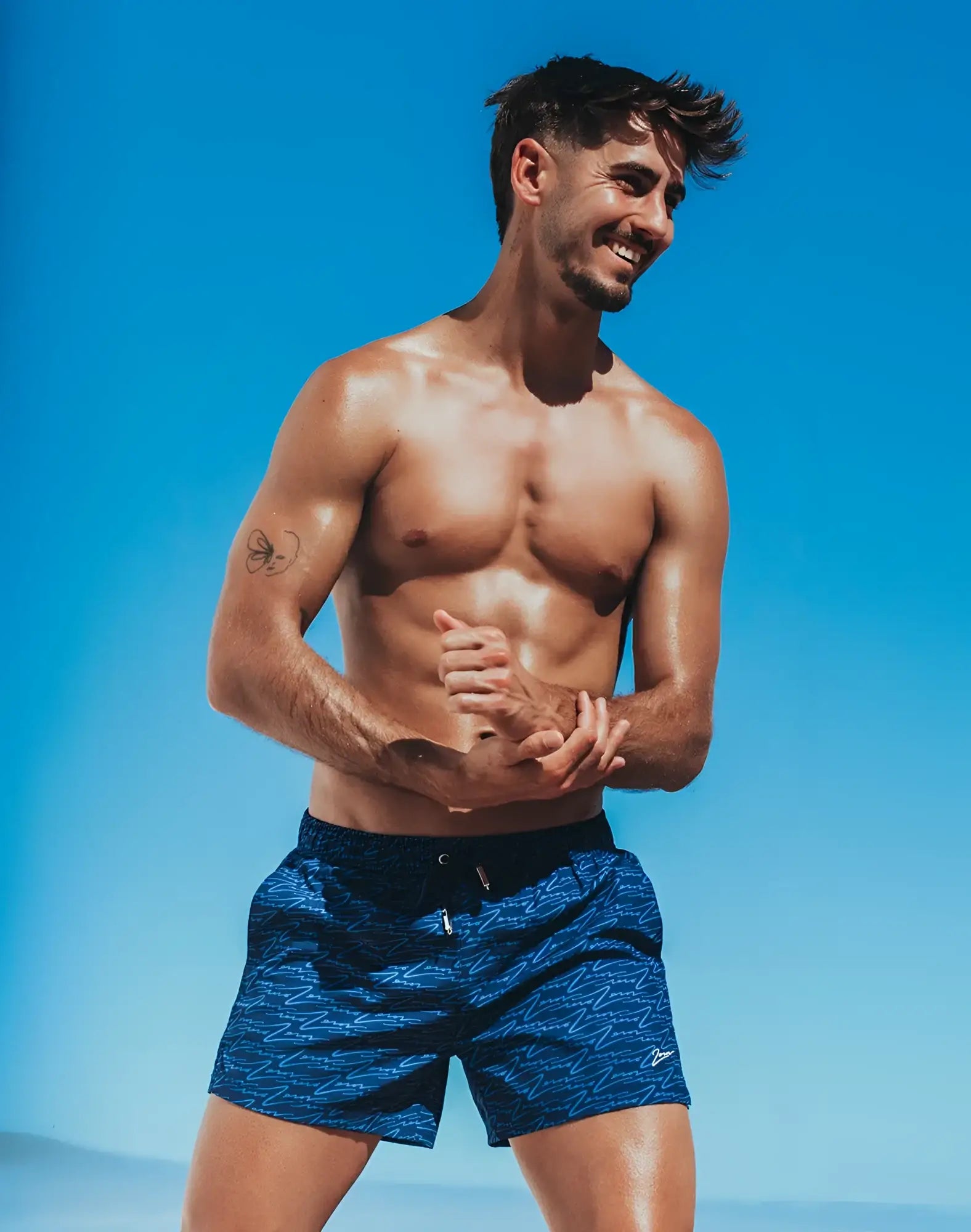Byron swim short with blue patterned fabric, subtle wave design, and black waistband for stylish swimwear