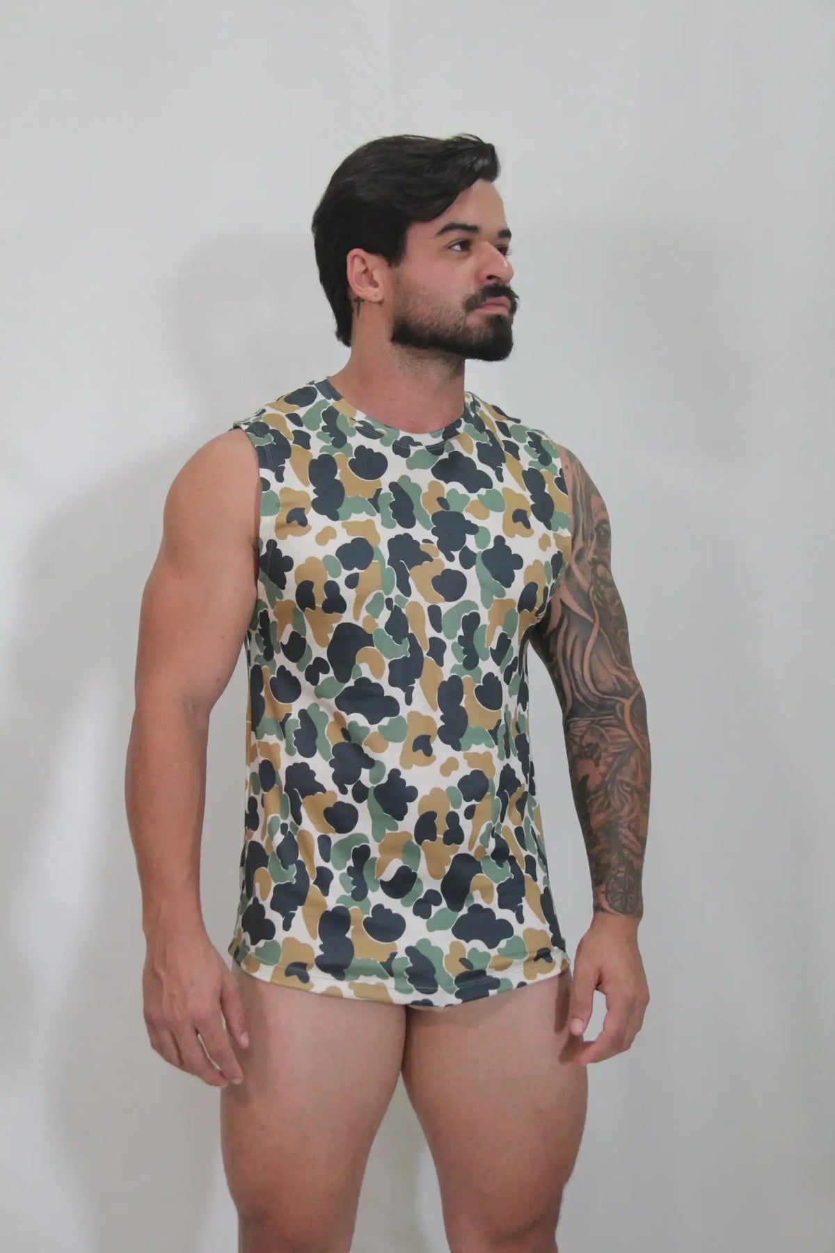 A men’s sleeveless camouflage open arm tank top in green brown and black on white for casual wear