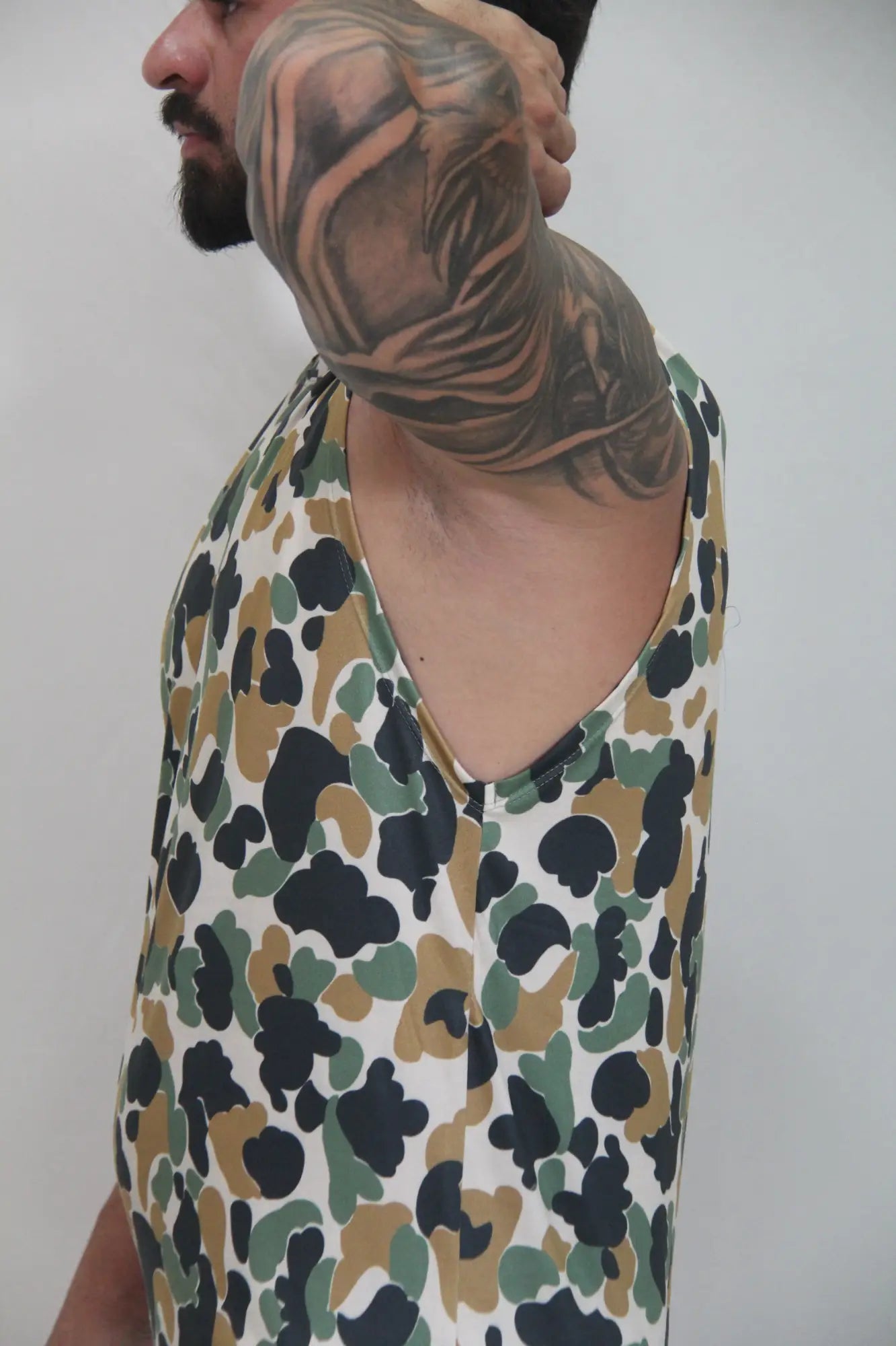 Camouflage open arm tank sleeveless top with white base black and olive green splotches for casual wear