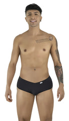 Model poses wearing black CandyMan trunks with a low-rise, form-fitting cut against a plain white background.