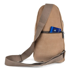 Tan canvas sling bag with adjustable shoulder strap and front zippered pocket holding a blue visa card