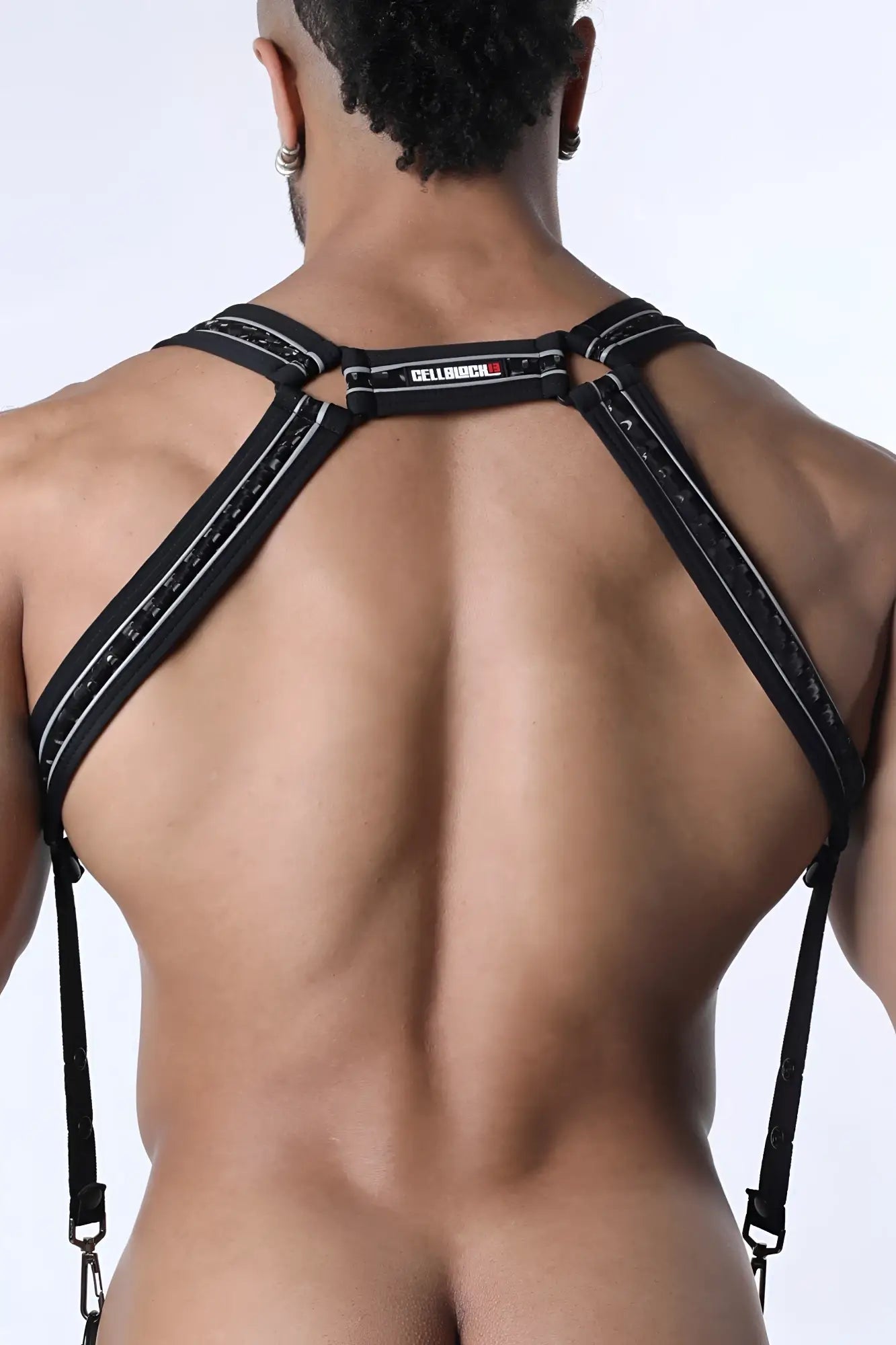 Back side of carbon shadow body harness featuring black lace-trimmed suspenders with silver stitching and cellbio label