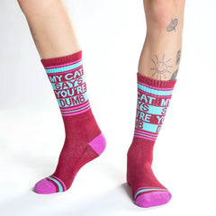 Maroon and pink crew socks with a light blue band and bold white text my cat says youre dumb with thin stripes