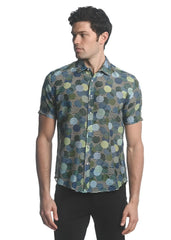 A men’s short-sleeved cotton silk shirt with vibrant green blue and yellow circle pattern on dark fabric