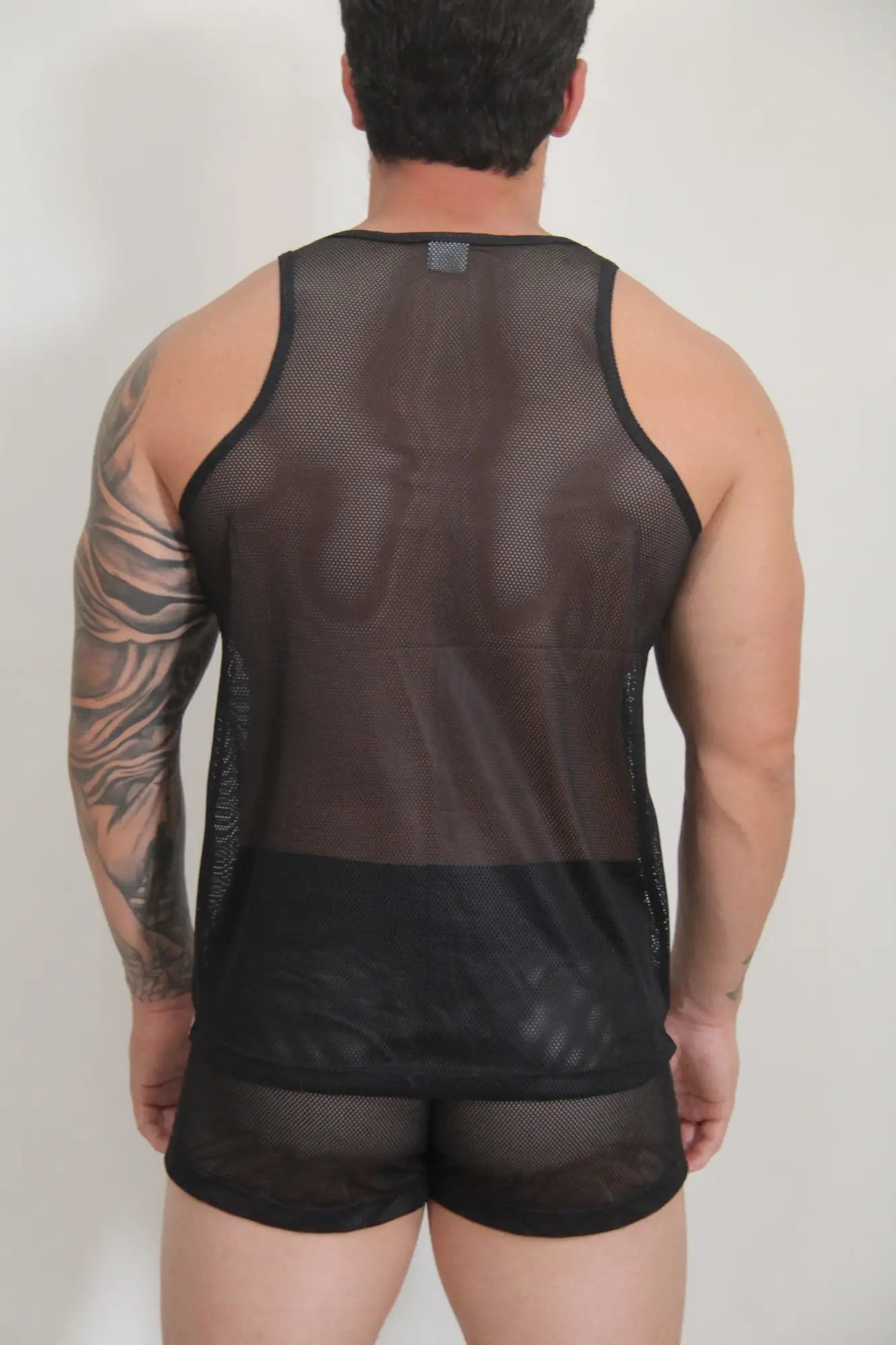 Black mesh tank top with solid black band at bottom from circuit mesh tanks available in four colors