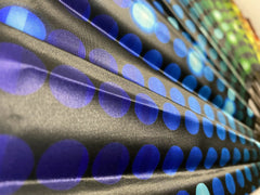 Black fabric from clack fans featuring overlapping blue circles pattern with smooth texture and subtle sheen