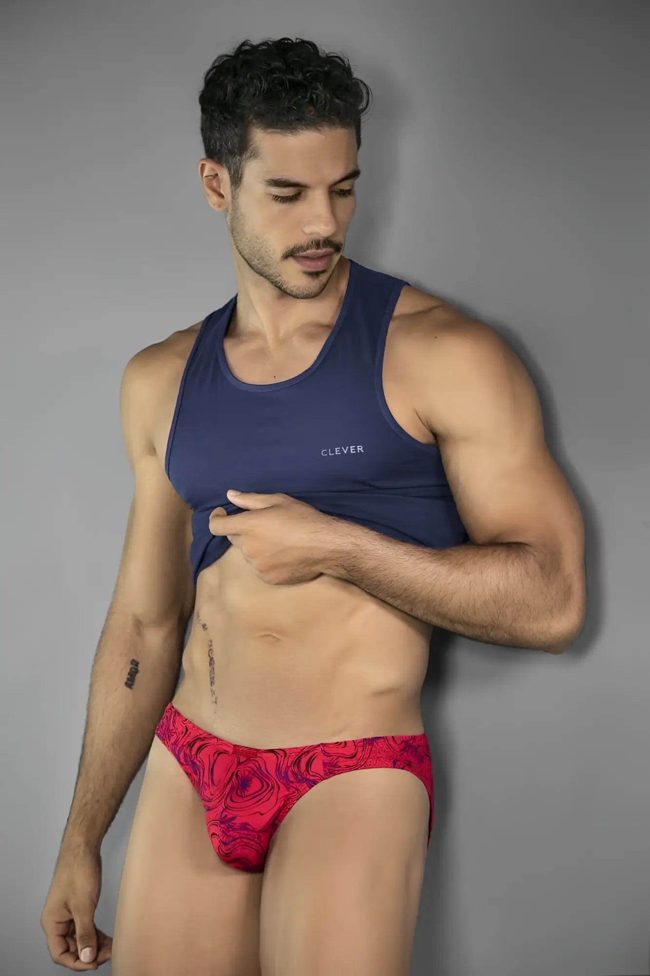 A vibrant red clever 26028 helion bikini with swirling black pattern and white embroidered brand name on navy tank top