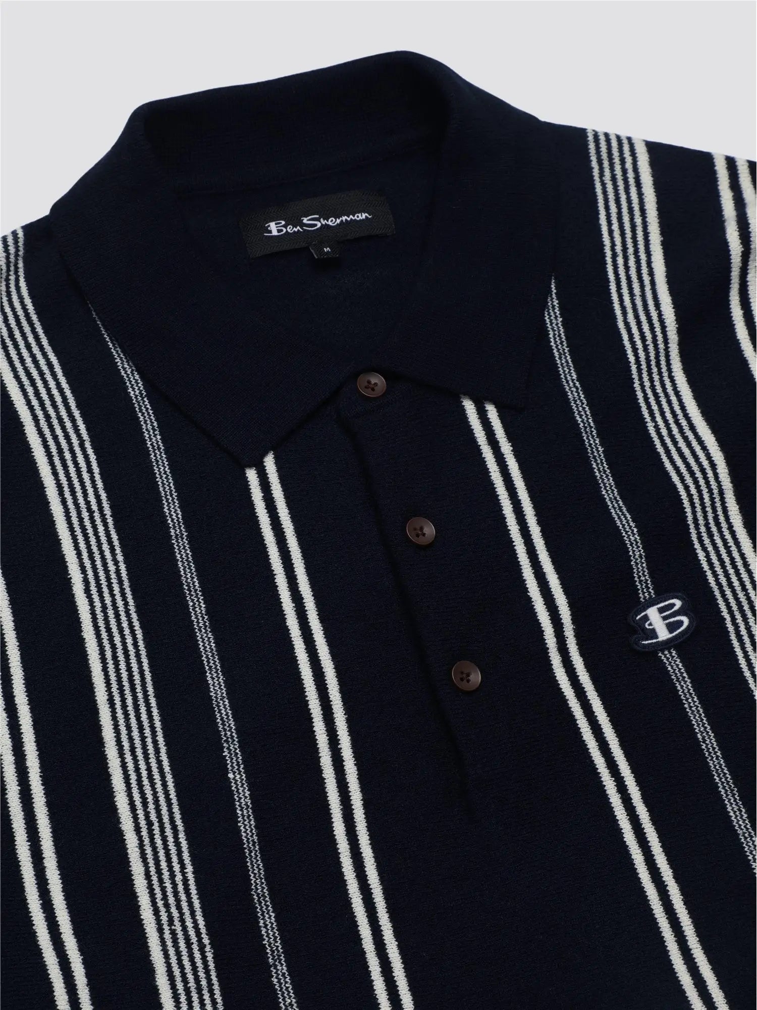 Navy blue and white striped crinkle cotton stripe polo shirt with a small embroidered logo on the chest