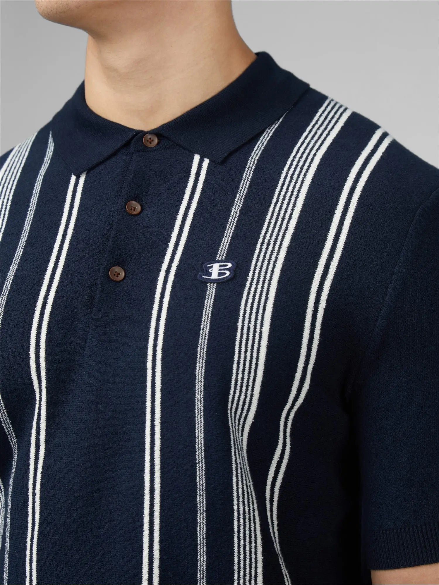 Navy blue and white vertically striped crinkle cotton polo shirt with small embroidered logo on left chest