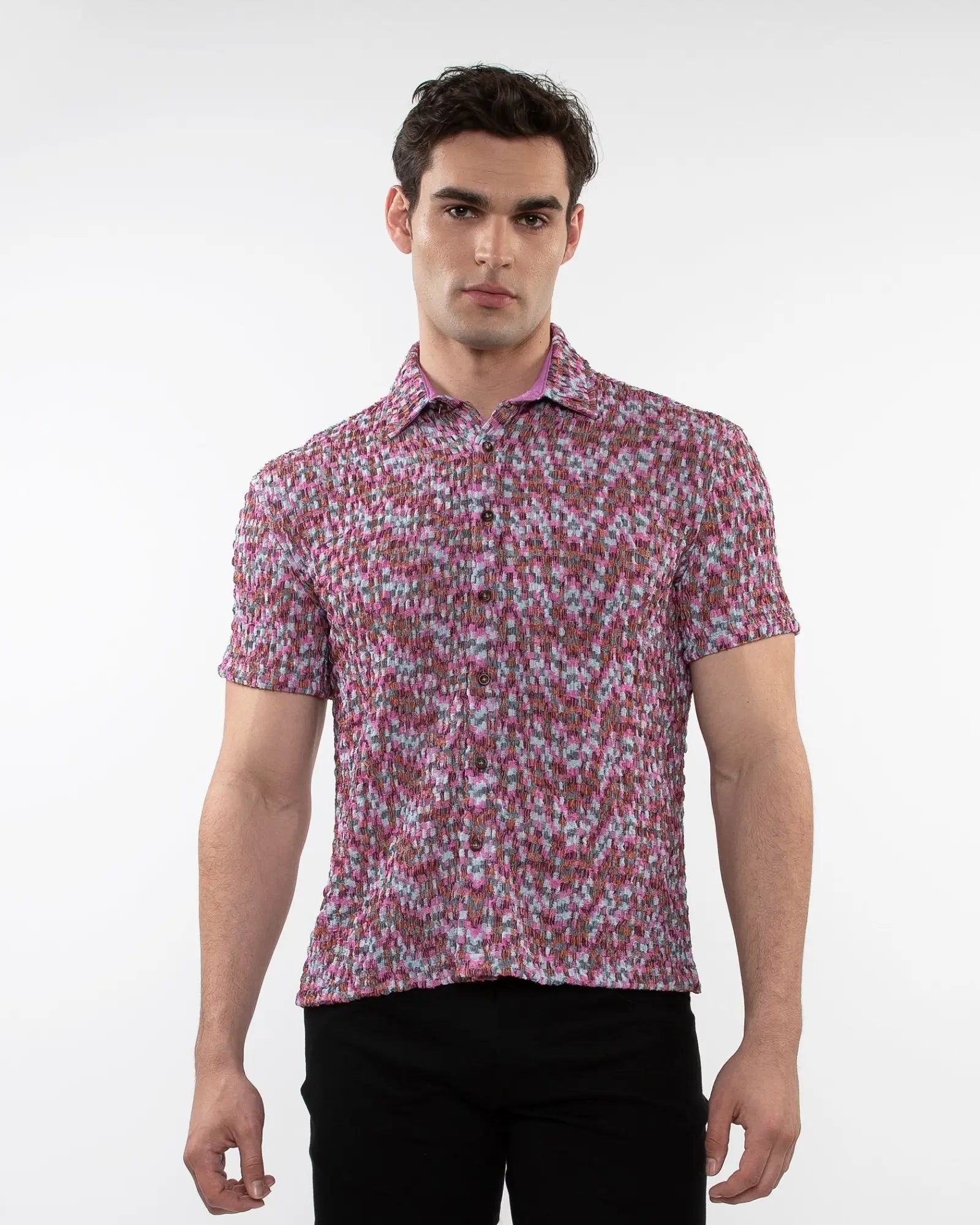 A man wearing a crinkle knit short sleeve shirt with a vibrant pink and white floral pattern