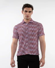 A man wearing a crinkle knit short sleeve shirt with a vibrant pink and white floral pattern