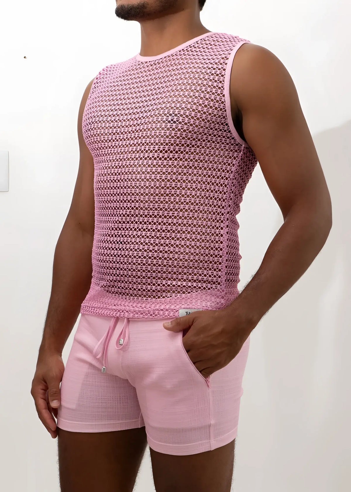 Pink crochet muscle tank top with mesh sleeveless design and subtle geometric pattern paired with matching drawstring shorts