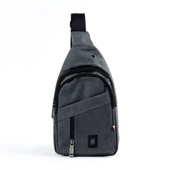 Gray textured fabric crossbody sling bag with black zipper pulls and small black logo patch