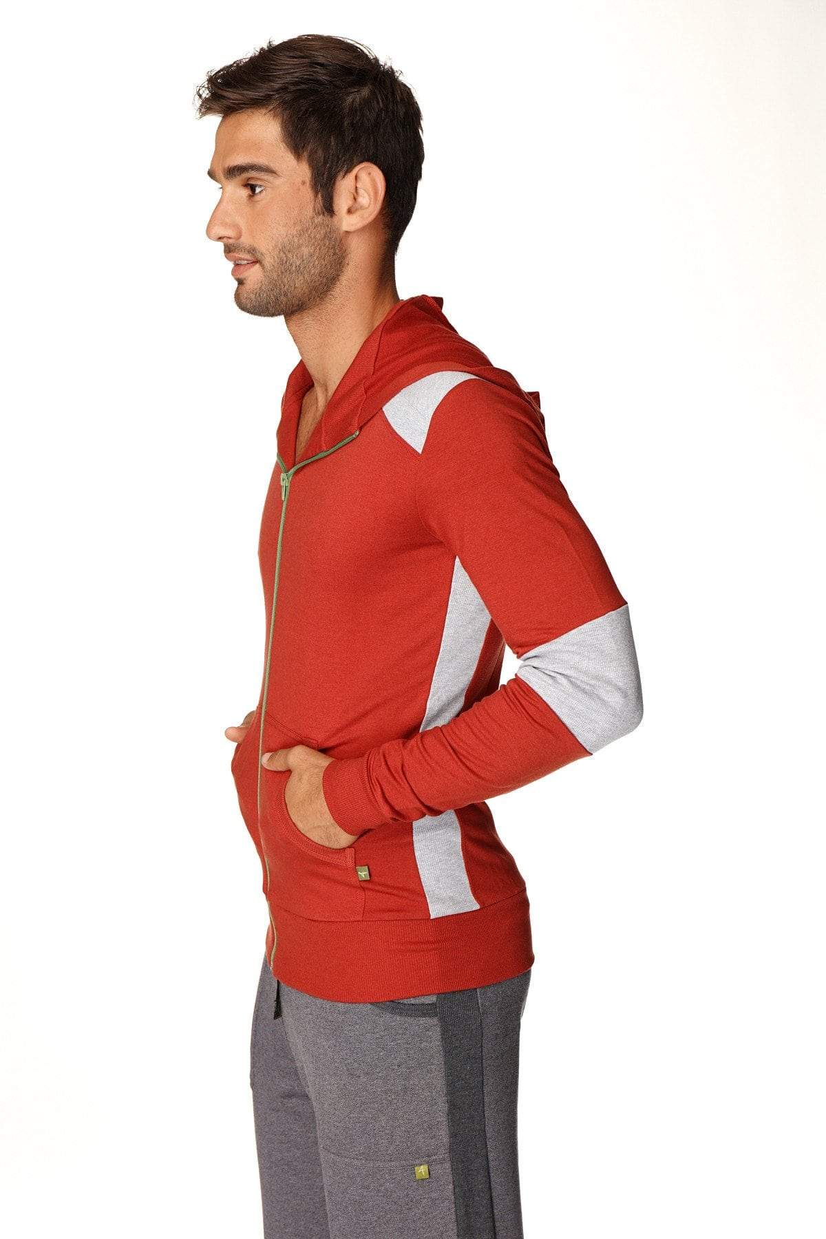 Form-fit crossover yoga track performance hoodie in cinnabar grey with red zip-up, white panels, gold zipper, and pockets