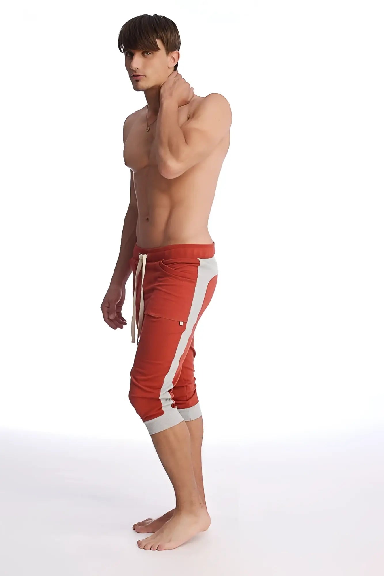 Red cuffed yoga pants in cinnabar with white side stripes and matching drawstring waistband for athletic wear