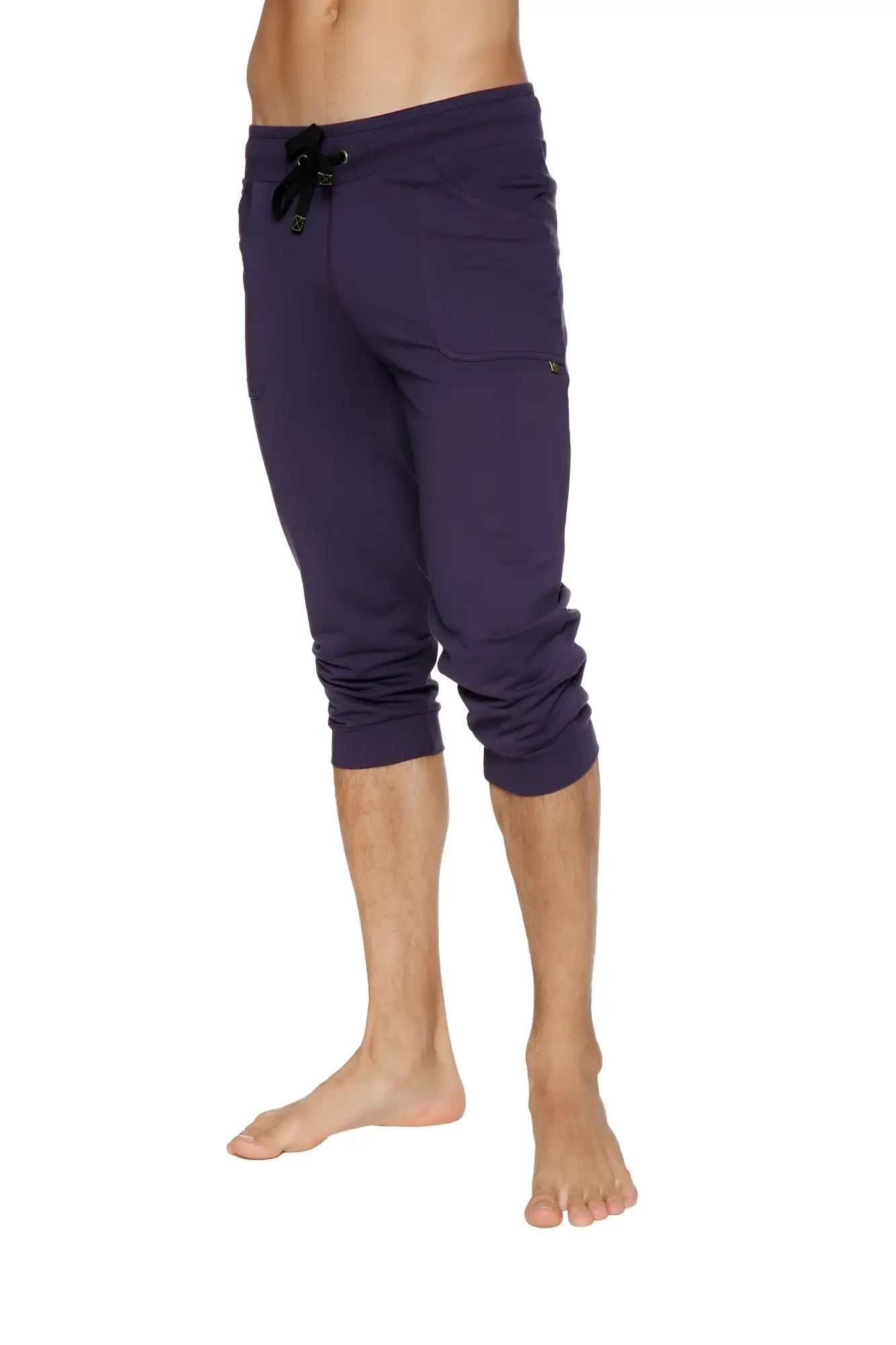 Purple cuffed yoga pants with black drawstring waistband and side pockets in a capri-length jogger style