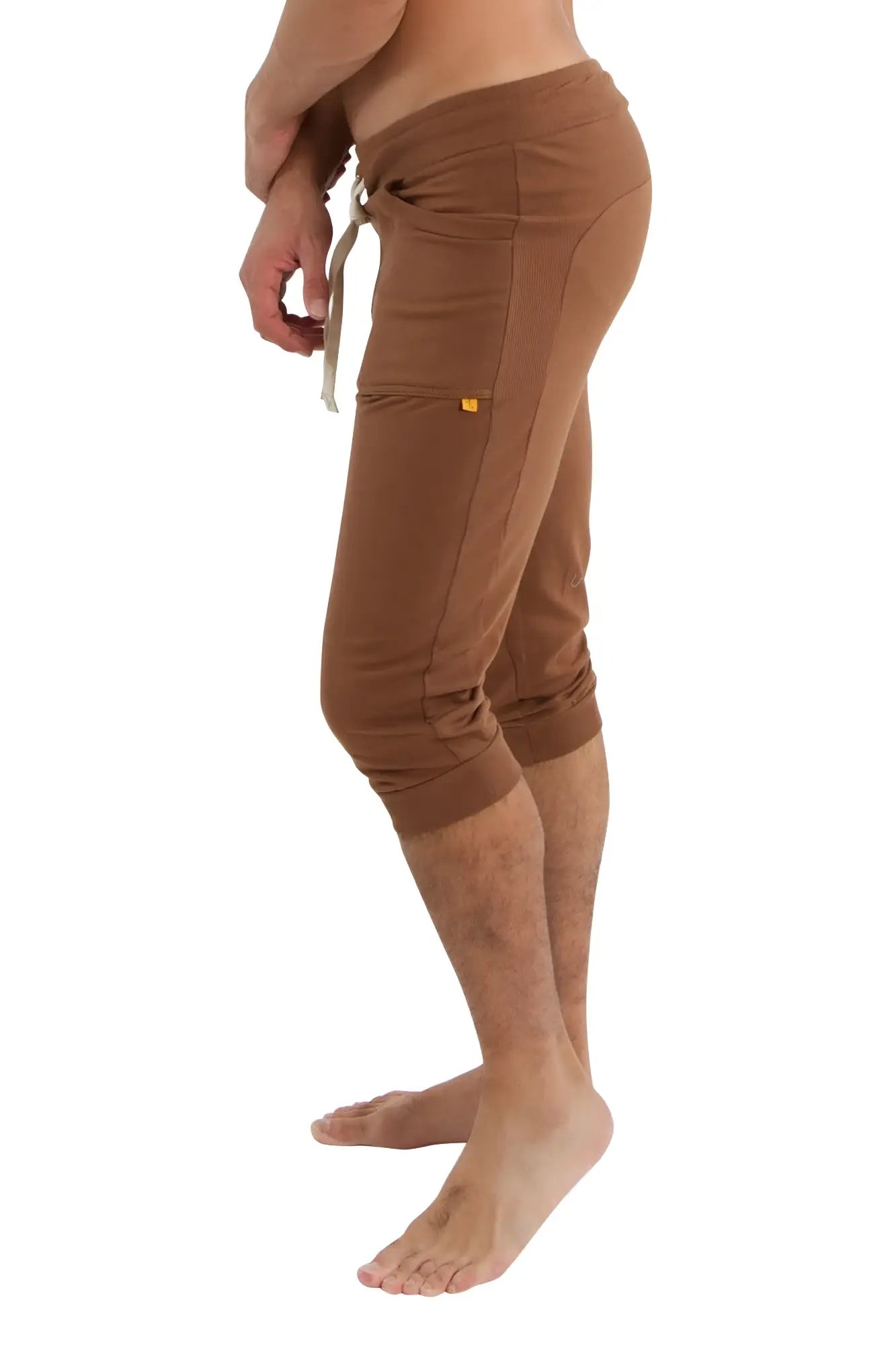 Brown cuffed yoga pants with drawstring waistband and side pockets made of comfortable fabric for athletic use