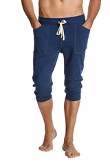 Navy blue cuffed yoga pants with white drawstring side pockets and capri-length jogger style for activewear