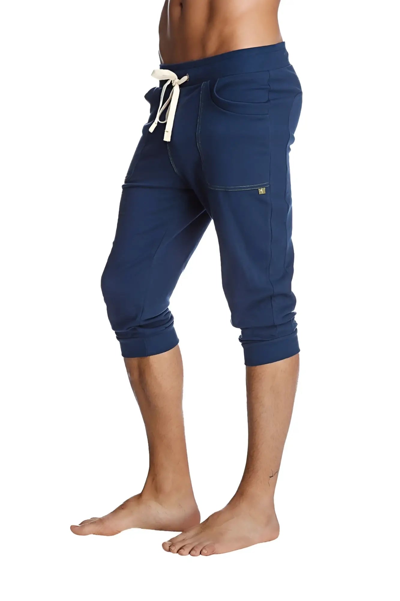 Navy blue cuffed yoga pants with white drawstring and side pockets made from soft fabric for comfortable wear