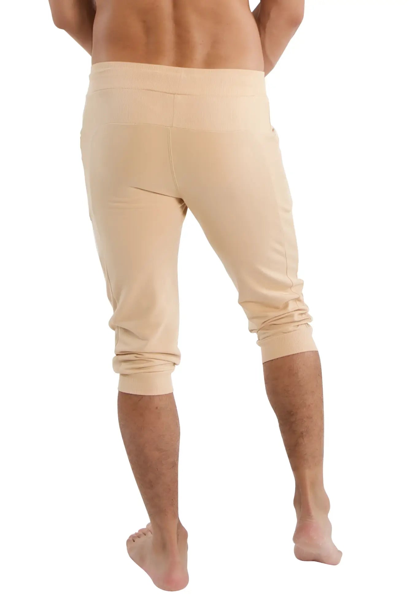 Beige cuffed yoga pants in soft stretchy fabric with rolled cuffs and capri length for comfortable workouts
