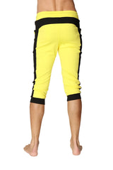 Bright yellow cuffed yoga capri pants with black side stripes and elastic waistband for comfortable movement