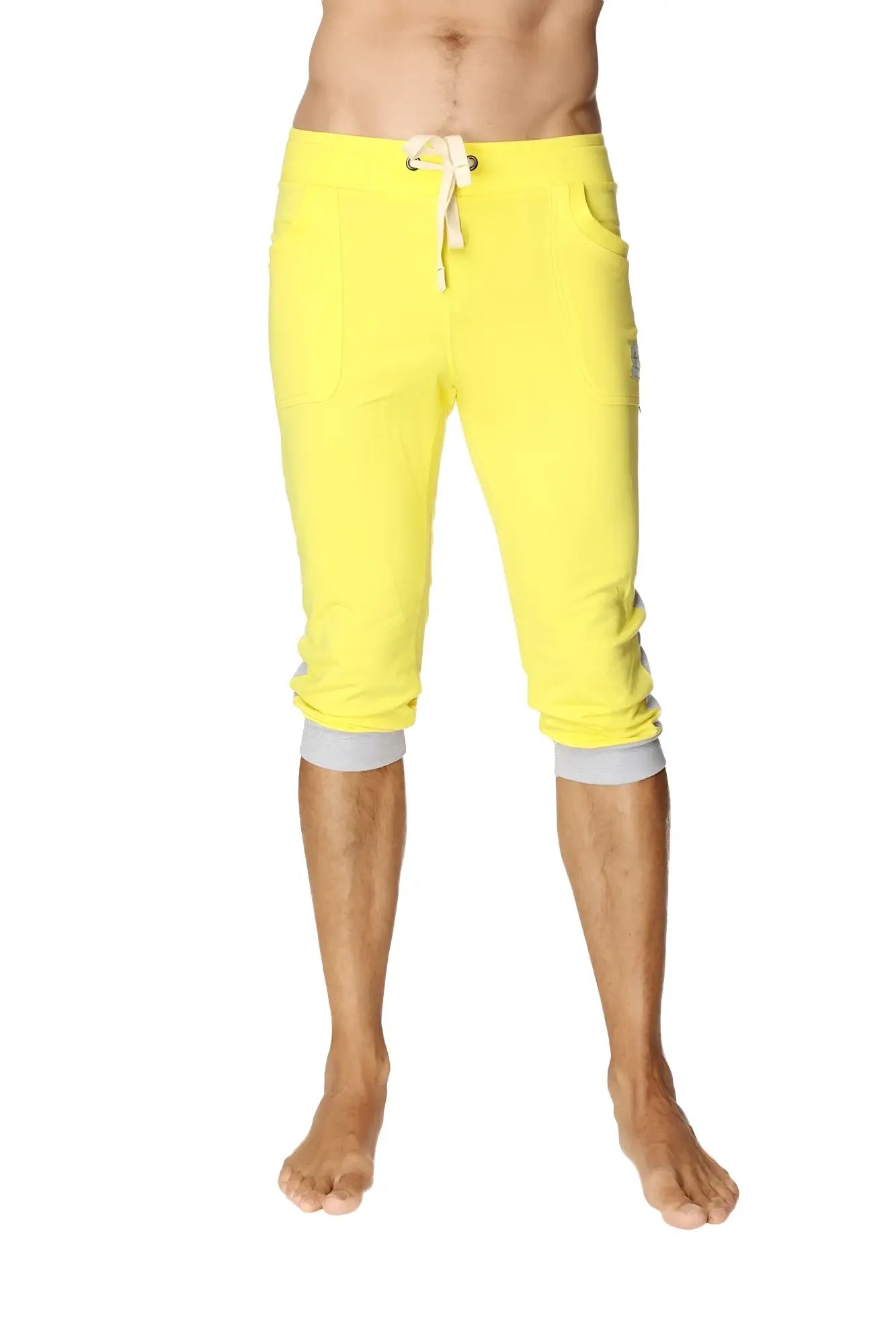 Bright yellow cuffed yoga pants with white drawstring and gray elastic cuffs in capri length for activewear