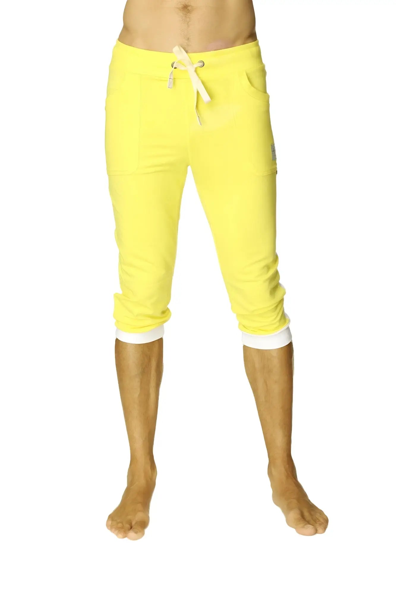 Bright yellow cuffed yoga pants with white drawstring and contrasting white cuffs in capri-length style