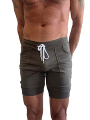 Olive green cuffed yoga shorts with ribbed waistband and white drawstring made for athletic wear