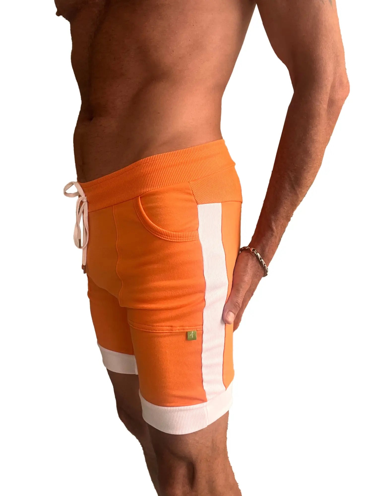 Cuffed yoga short in orange with white vertical stripes and ribbed cuffs designed for athletic wear