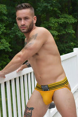 Yellow striped briefs with black trim and a branded waistband label from the Cumdump Jock collection