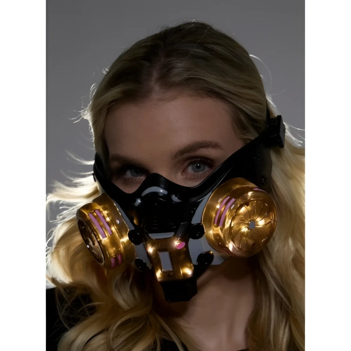 Black and gold cyberpunk light up mask with glowing pink accents on circular filters for futuristic style