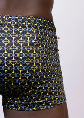 Black designer buckle print sq cut trunk swim trunks with bold interlocking yellow and light blue horseshoe logos