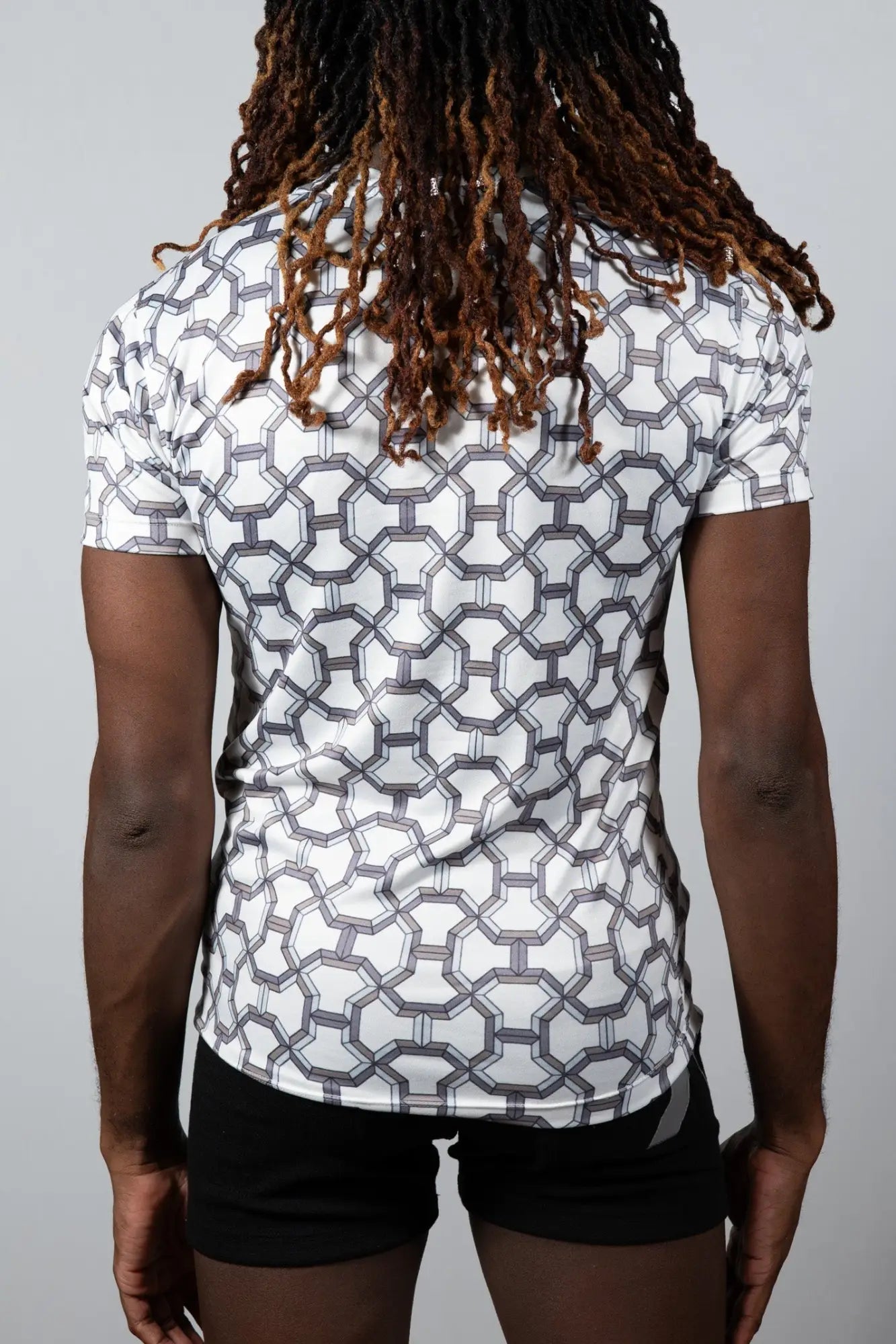 White short-sleeved athletic shirt with a geometric gray pattern designed for performance and style