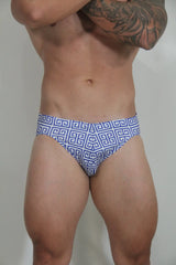 Designer print swim brief featuring blue and white geometric greek key pattern on patterned fabric