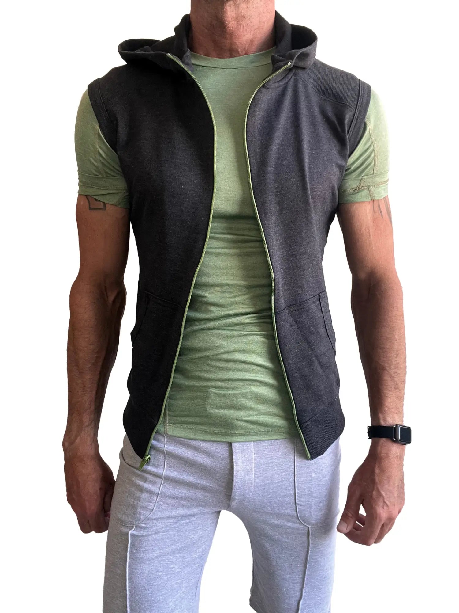 Dark gray hooded vest with light green zipper and lining worn over sage green designer raglan crew neck tee
