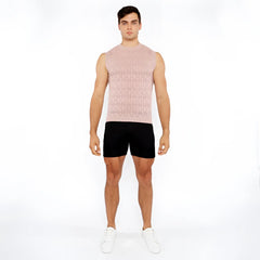 A man wearing a light pink sleeveless diamond pointelle knit vest with an intricate diamond-patterned design